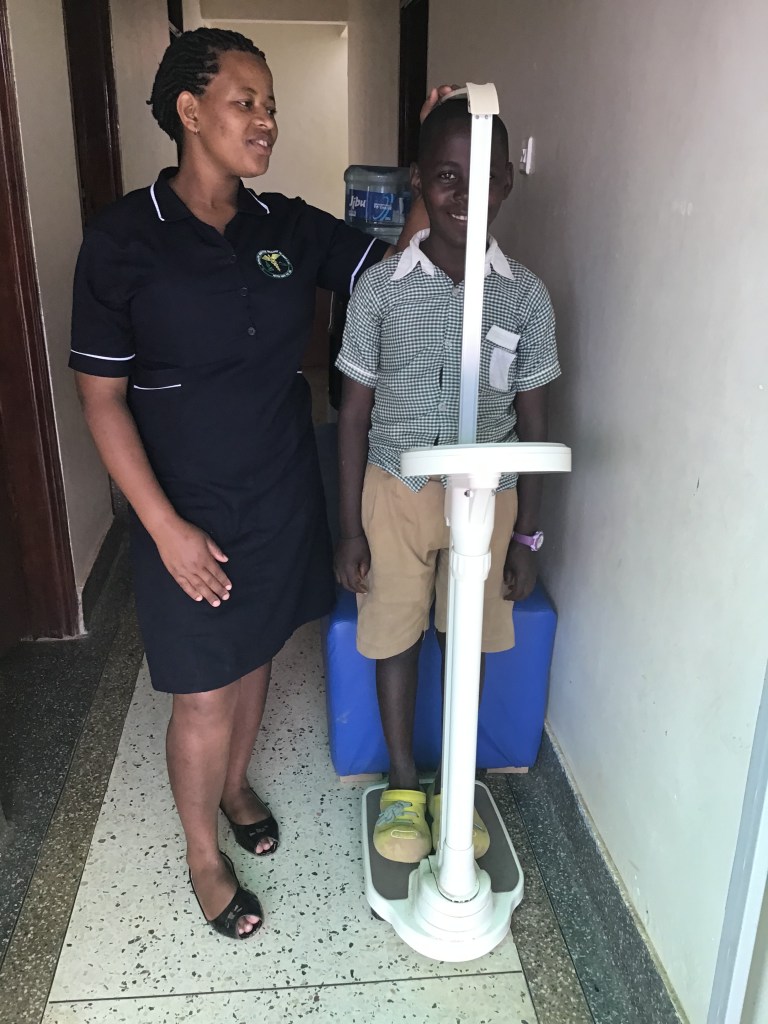A nurse doing biometric assignments during the general health checks before Joshua goes to school for a new term